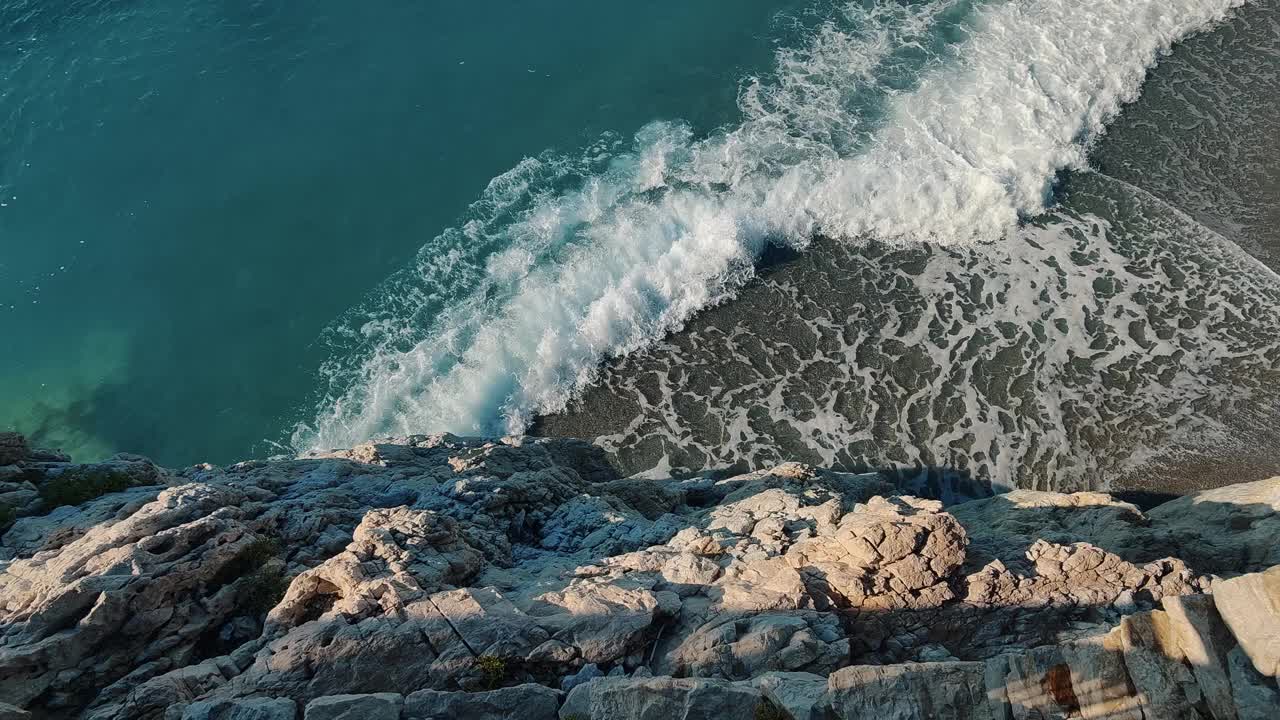 绿松石海浪冲击岩石海岸线，完美的自然海报视频下载