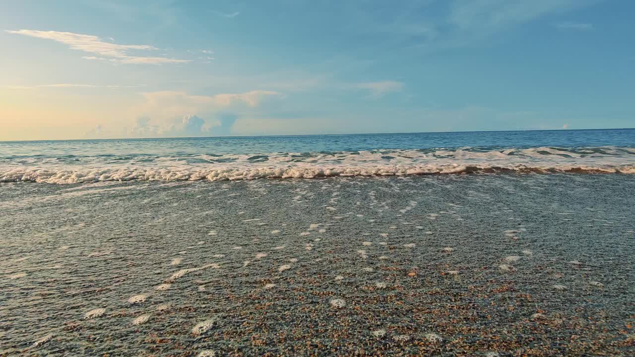 夏天黎明的海滩。大海和波浪，蓝色的背景是一个透明的天空。海卵石。视频素材