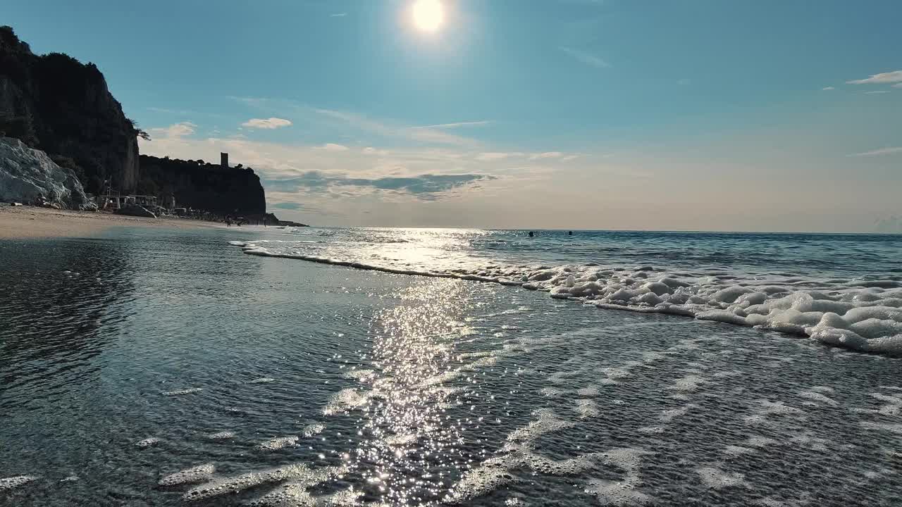 宁静的海滨与太阳在日落的海浪上闪闪发光视频下载