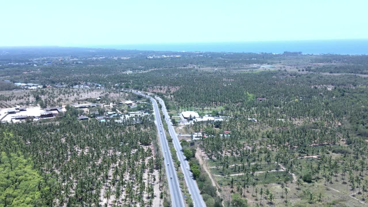 鸟瞰图在一个晴朗的日子里，汽车沿着沿海高速公路行驶。视频下载