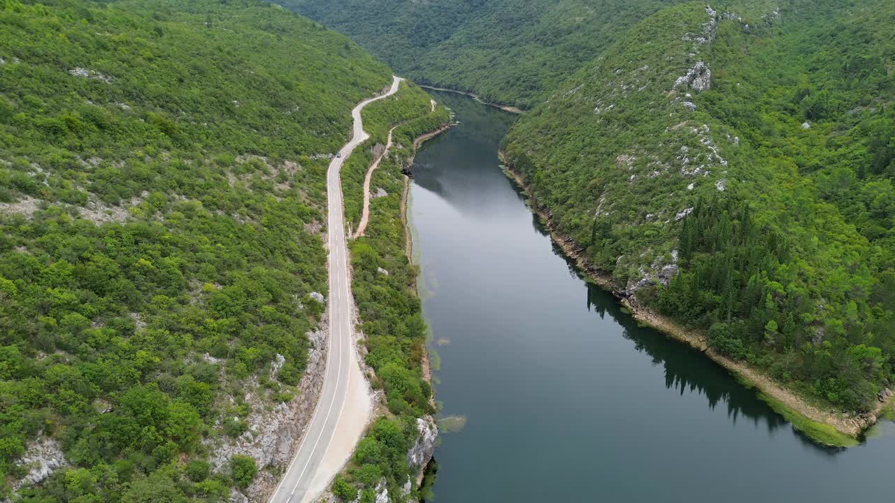 无人机镜头的一个风景驾驶的湖通过山区地形视频下载