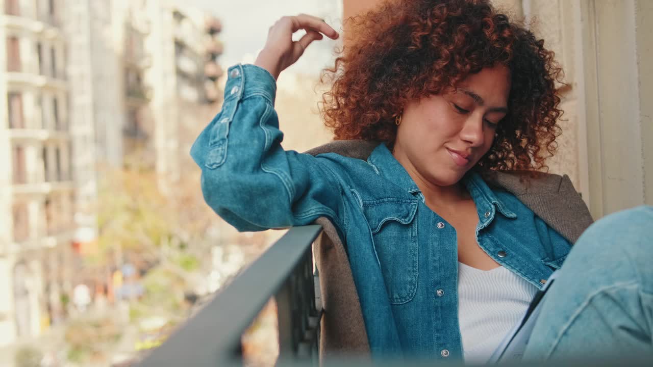 年轻女子坐在阳台上，手里拿着日记视频素材