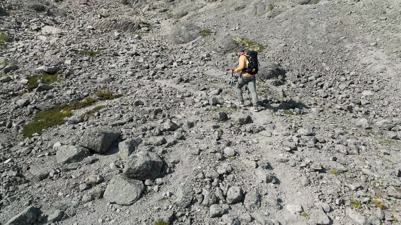 男徒步旅行者沿着布满岩石的小路走到山顶视频素材