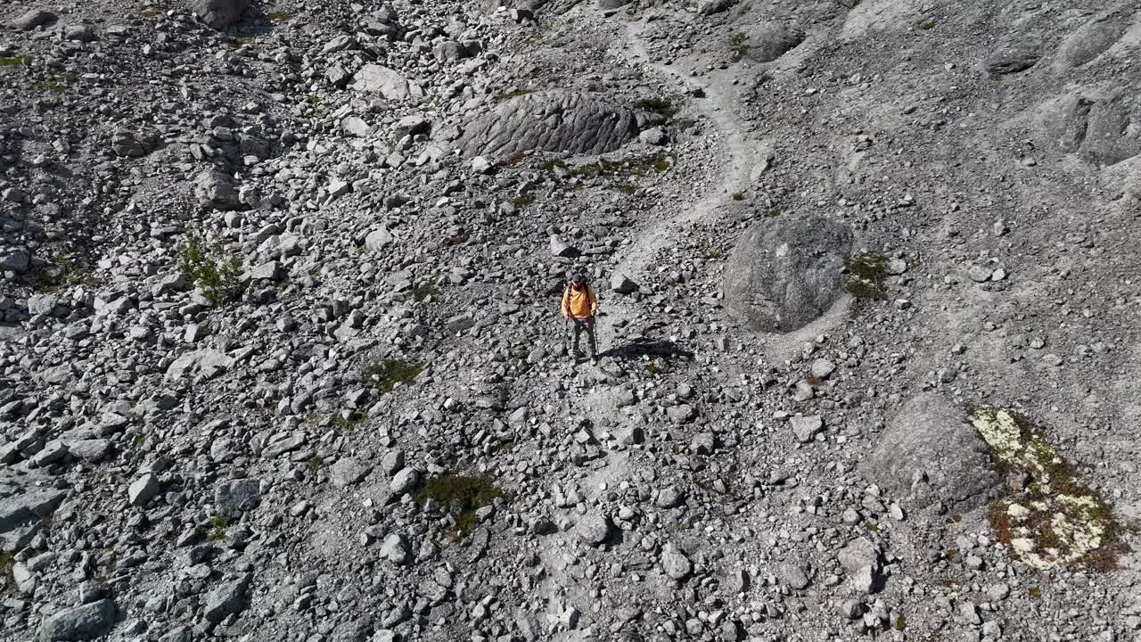 鸟瞰图，徒步旅行者在岩石山坡上，举起双手视频下载