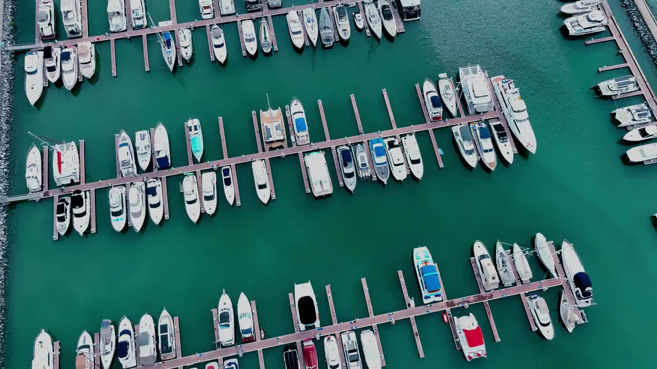 海上，港口，船只和城市建筑的空中无人机视图。度假小镇的壮丽景色，乘坐不同大小的游艇飞越滨海湾视频下载