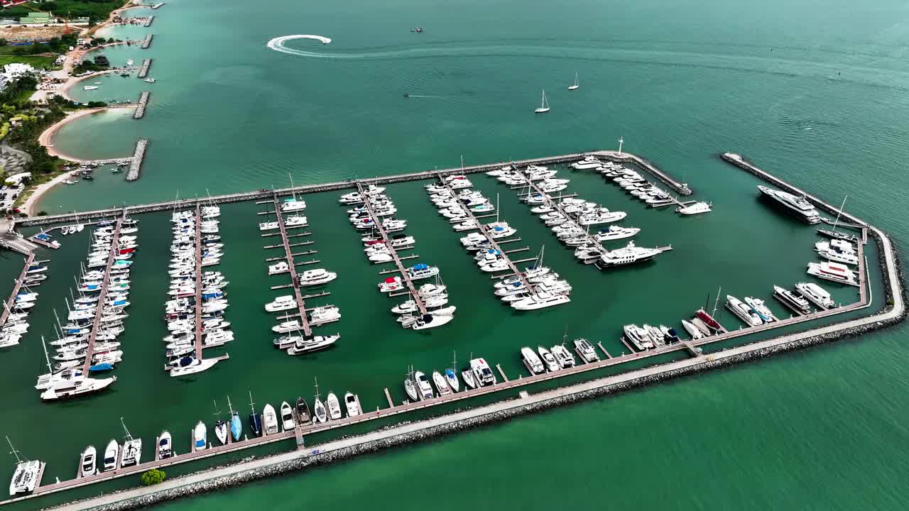 海上，港口，船只和城市建筑的空中无人机视图。度假小镇的壮丽景色，乘坐不同大小的游艇飞越滨海湾视频素材