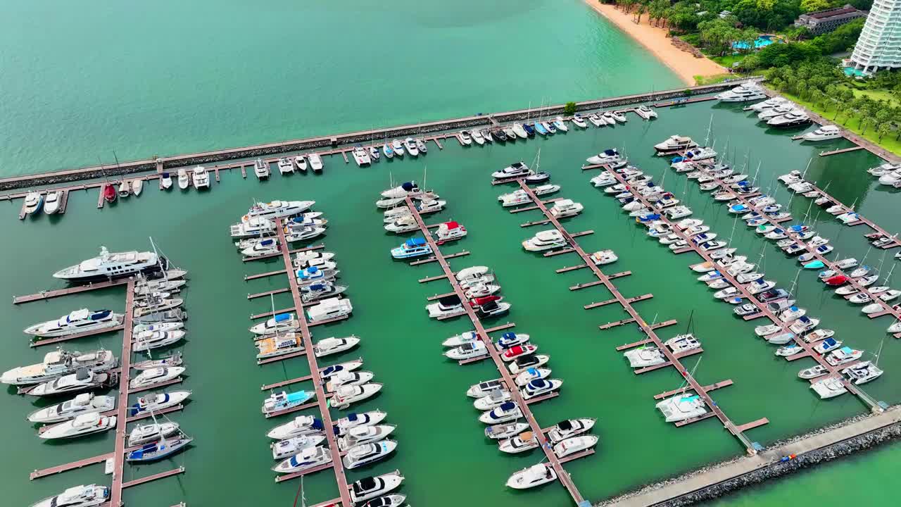 海上，港口，船只和城市建筑的空中无人机视图。度假小镇的壮丽景色，乘坐不同大小的游艇飞越滨海湾视频下载