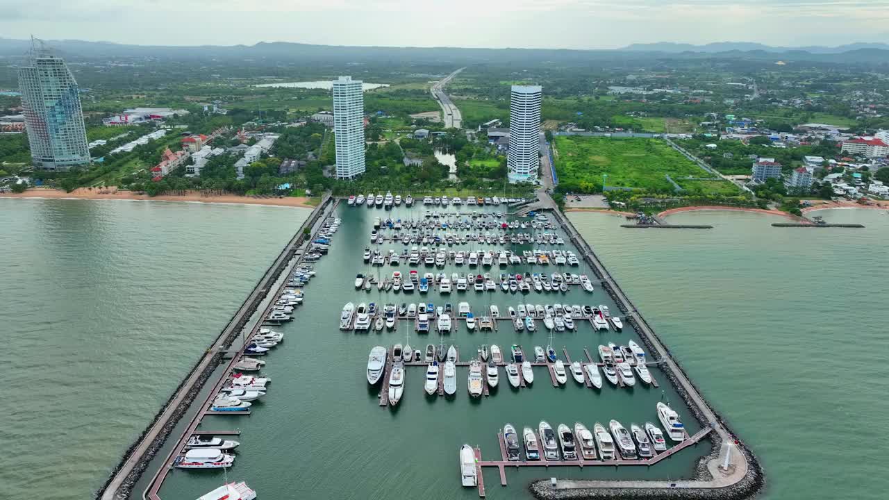 海上，港口，船只和城市建筑的空中无人机视图。度假小镇的壮丽景色，乘坐不同大小的游艇飞越滨海湾视频下载