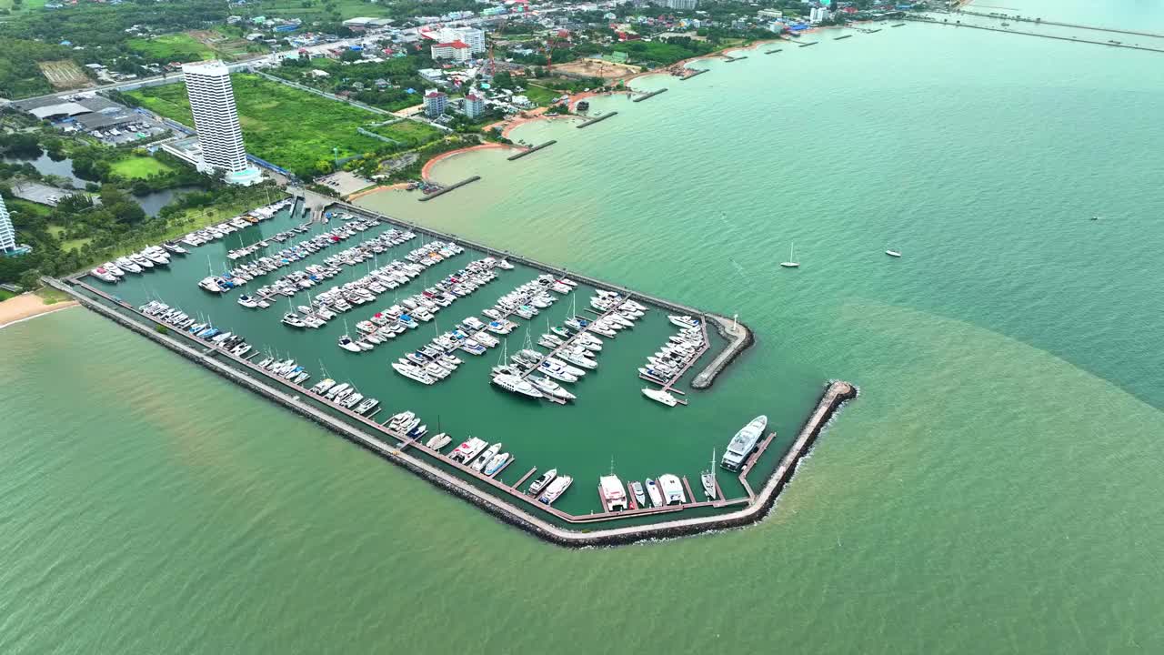 海上，港口，船只和城市建筑的空中无人机视图。度假小镇的壮丽景色，乘坐不同大小的游艇飞越滨海湾视频素材