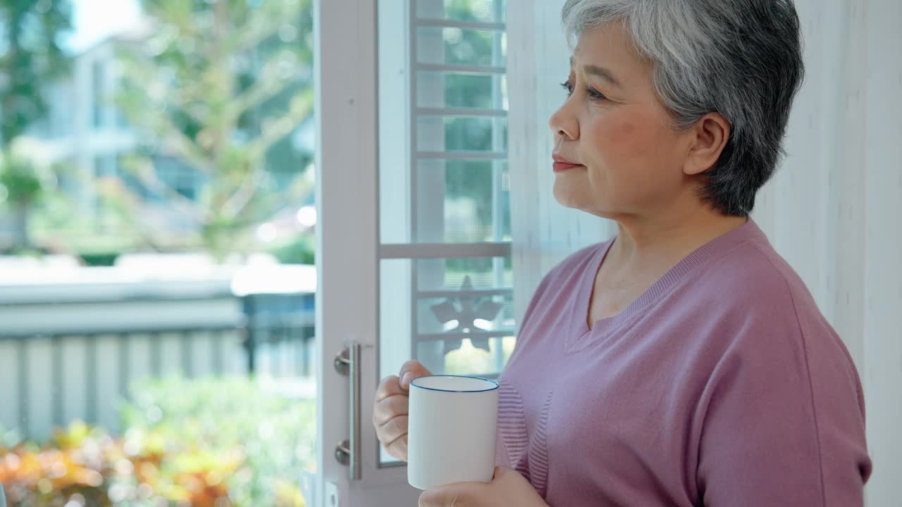 一位老妇人端着杯子站在假日橱窗旁视频下载