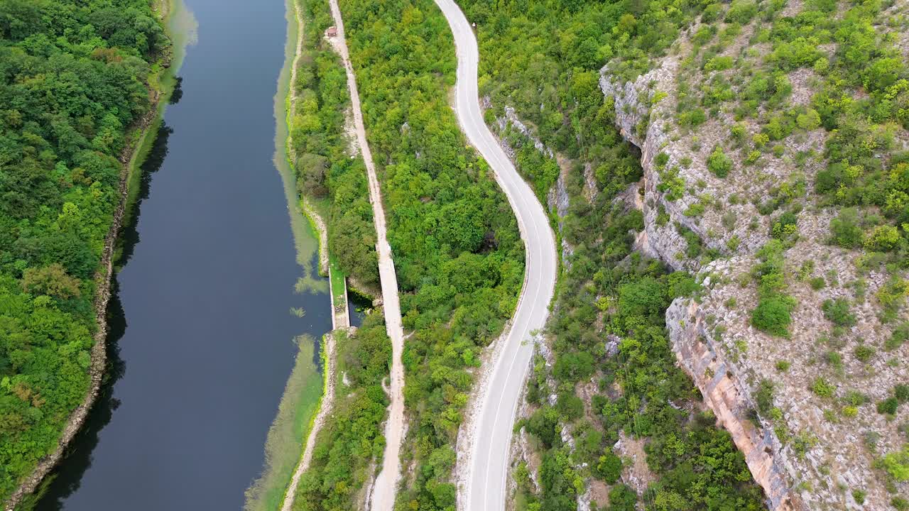 丘陵地带湖滨蜿蜒道路上的汽车行驶视频素材