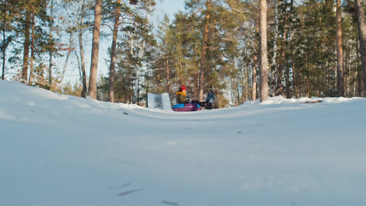 男孩在雪管上滑向镜头的慢镜头视频素材