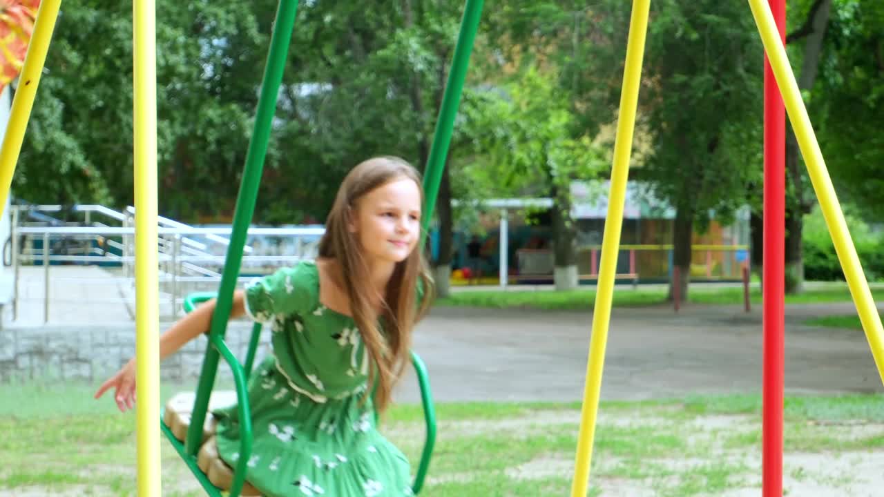 快乐的小女孩笑着荡秋千，带着积极的情绪享受童年的夏日户外游乐场。孩子飞翔玩耍欢快活动兴奋享受自由视频下载