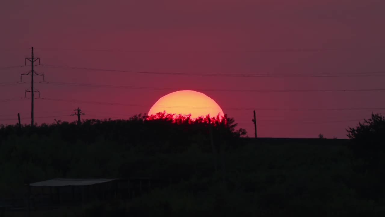 太阳下山了，隐藏在地平线下。夕阳下，乡村的混凝土电线杆上架起了电线视频下载