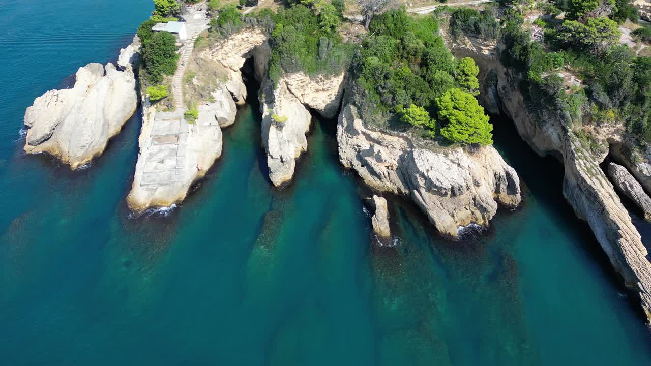 在一个阳光明媚的夏日，鸟瞰地中海沿岸风景如画的岩石裂缝视频素材