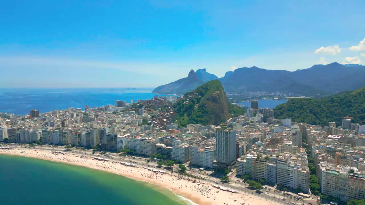 鸟瞰风景优美的海滨城市与山区背景在里约热内卢，展示城市和自然美景在一个阳光明媚的日子。视频素材