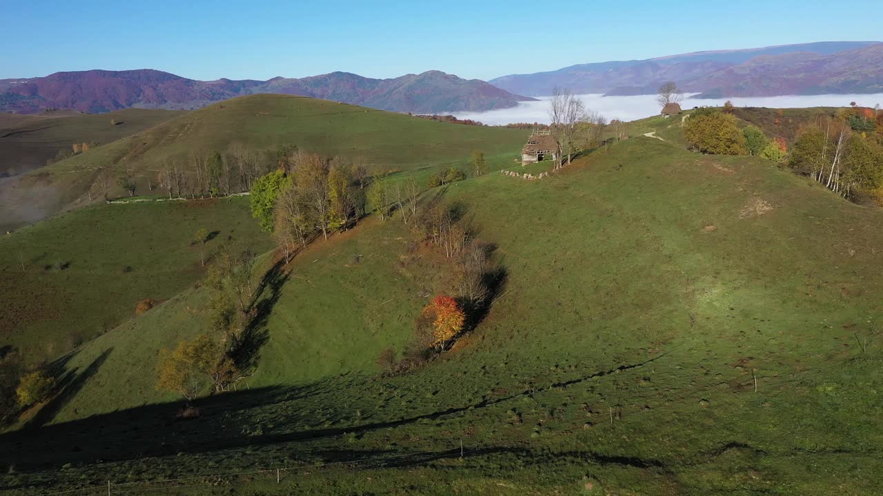 鸟瞰山间牧场，秋天茅草屋顶的木屋视频素材