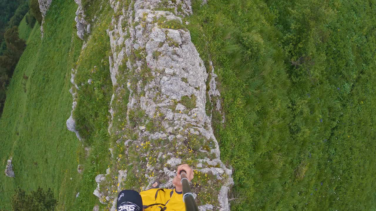 一个徒步旅行者穿着运动凉鞋沿着狭窄的山脊行走的俯视图视频下载