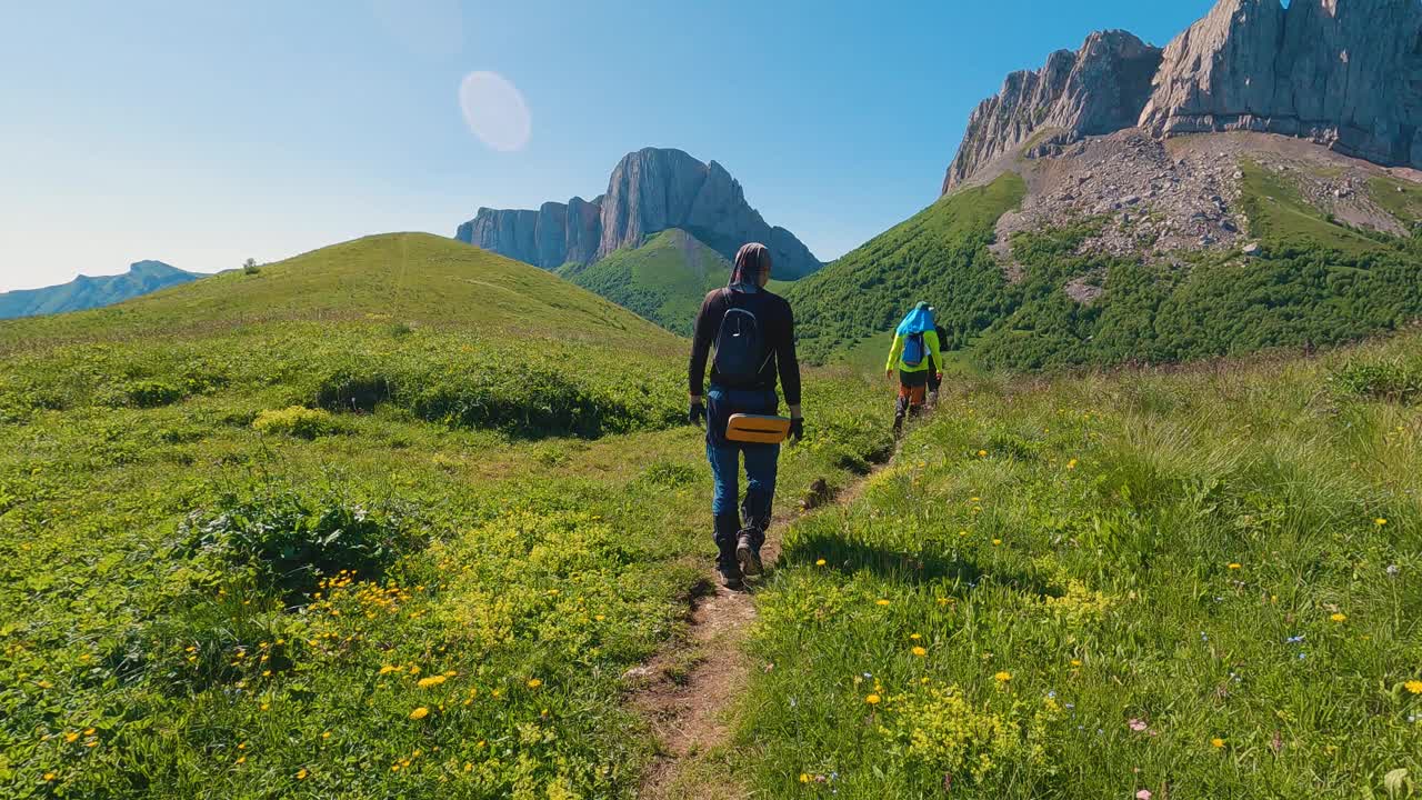 摄像机跟随一群徒步旅行者沿着山间小路行走视频下载