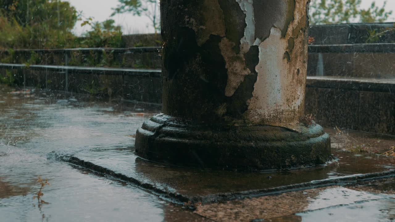 下雨天的场景，雨滴落在老柱子基座上。雨声，平静而忧郁的气氛。适合天气、自然、放松和孤独的主题。带声音的视频视频下载