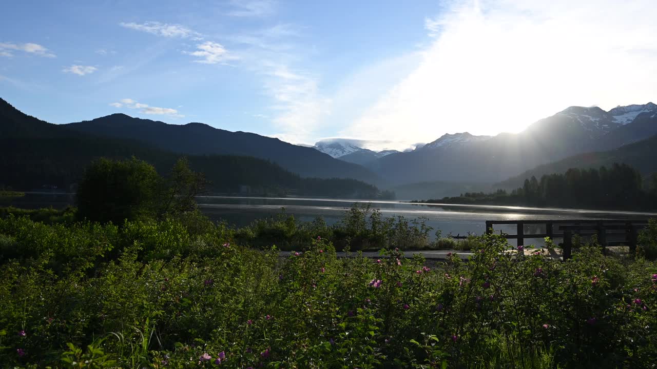 朋友们沿着指定的自行车道骑自行车，可以看到湖和山视频素材