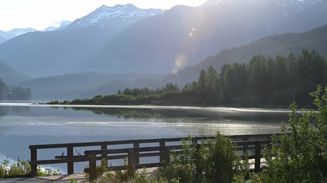 朋友们沿着指定的自行车道骑自行车，可以看到湖和山视频素材