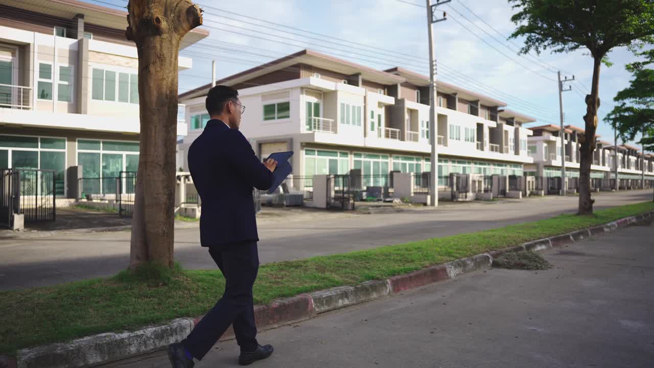 一位房地产商人正在察看一幢打算出租的大楼。一位年轻的男性房地产经纪人正在巡视楼层，并在户外检查房产。视频下载