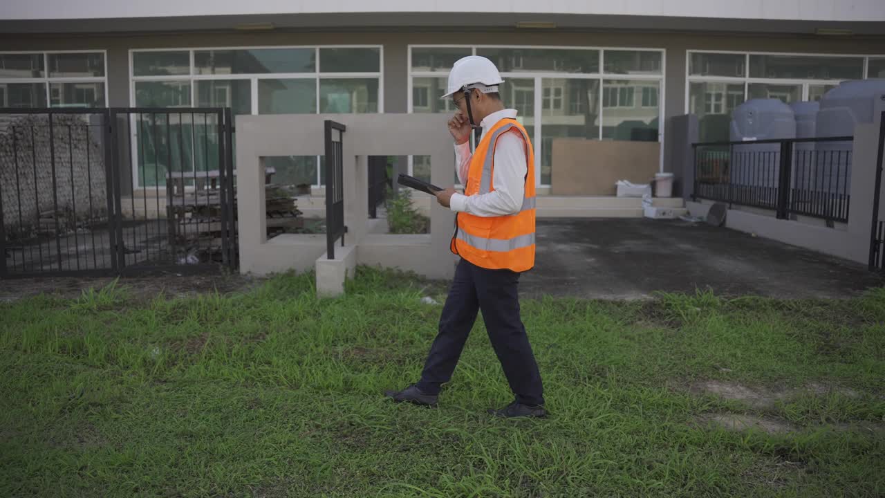 戴着安全帽的年轻男工程师手持建筑检查板进行装修检查项目房地产开发4k视频慢动作视频素材