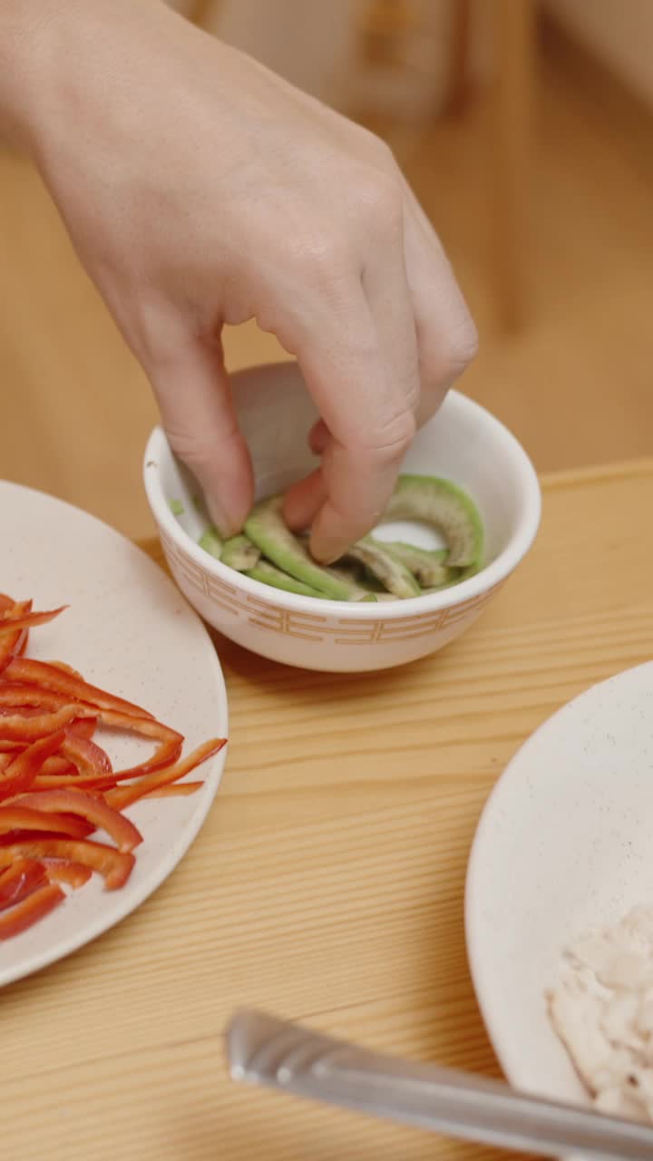 垂直视频。女人把鳄梨片加到墨西哥卷饼里，完成了新鲜而多彩的馅料。视频下载