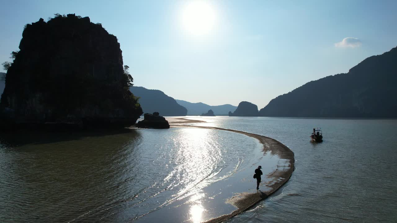 在亚洲泰国南部攀牙省攀牙湾，游客们沿着沙洲散步，欣赏日落。视频下载