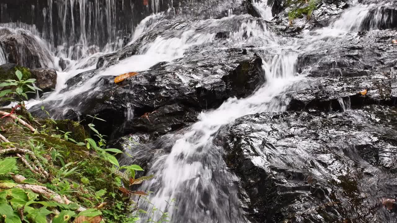 瀑布的水顺着岩石流下来。视频下载