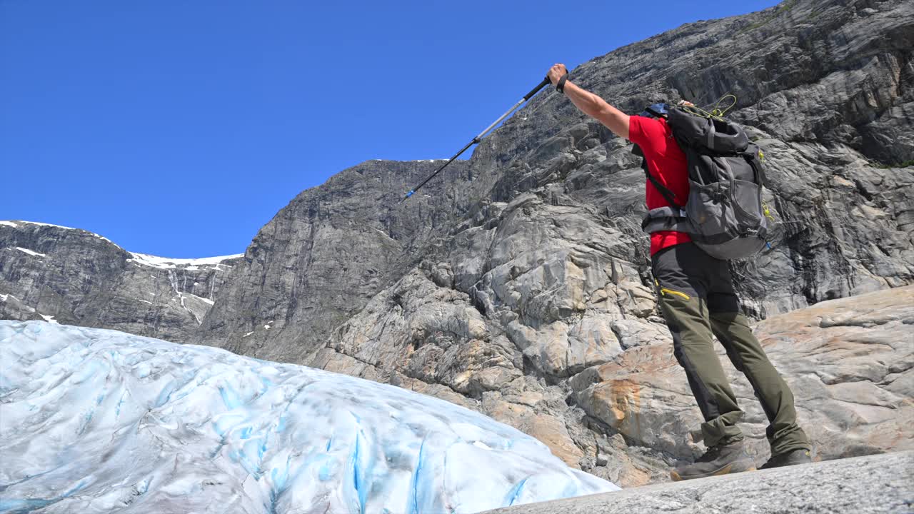 徒步旅行者在夏季晴朗的蓝天下探索山区的冰川视频下载