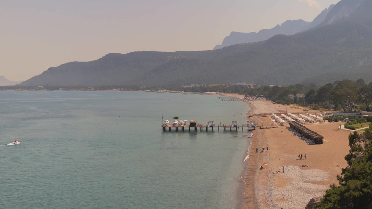 夏日晴朗的日子里，空旷的沙滩上有太阳床和遮阳伞视频下载