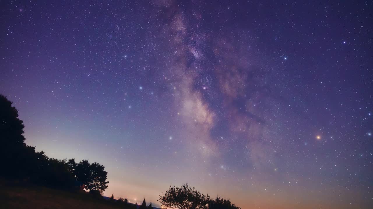 银河系的星星延时拍摄流星雨的轨迹和乡村的剪影拍摄的星跟踪天文摄影座。视频下载