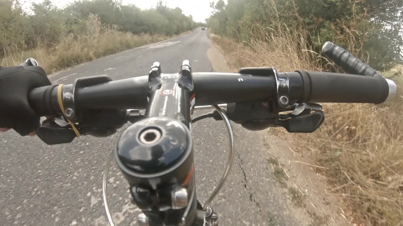 公路自行车POV。朋友们在夏日的乡间小路上骑车。视频下载