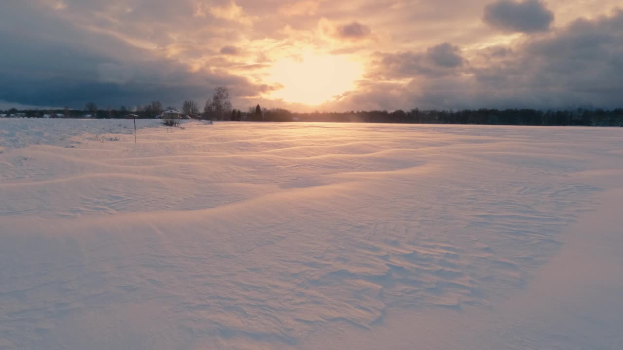 一个宁静而美丽的冬季日落闪耀在风景如画的雪景上视频素材