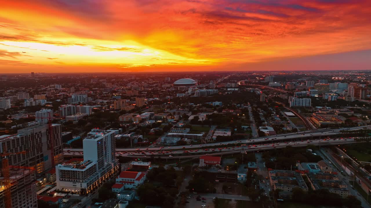 橙色明亮燃烧的天空在日落时，上面是广阔的城市风景。美国佛罗里达州迈阿密日落时的全景。视频下载