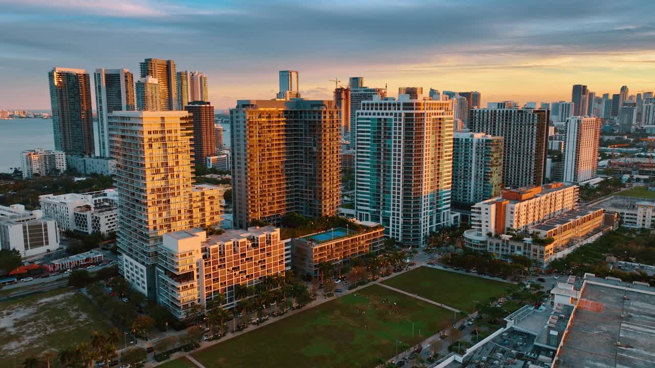 明亮的橘黄色夕阳照在高层建筑的立面上。美国佛罗里达州迈阿密海滩日落时无人机拍摄的全景画面。视频下载