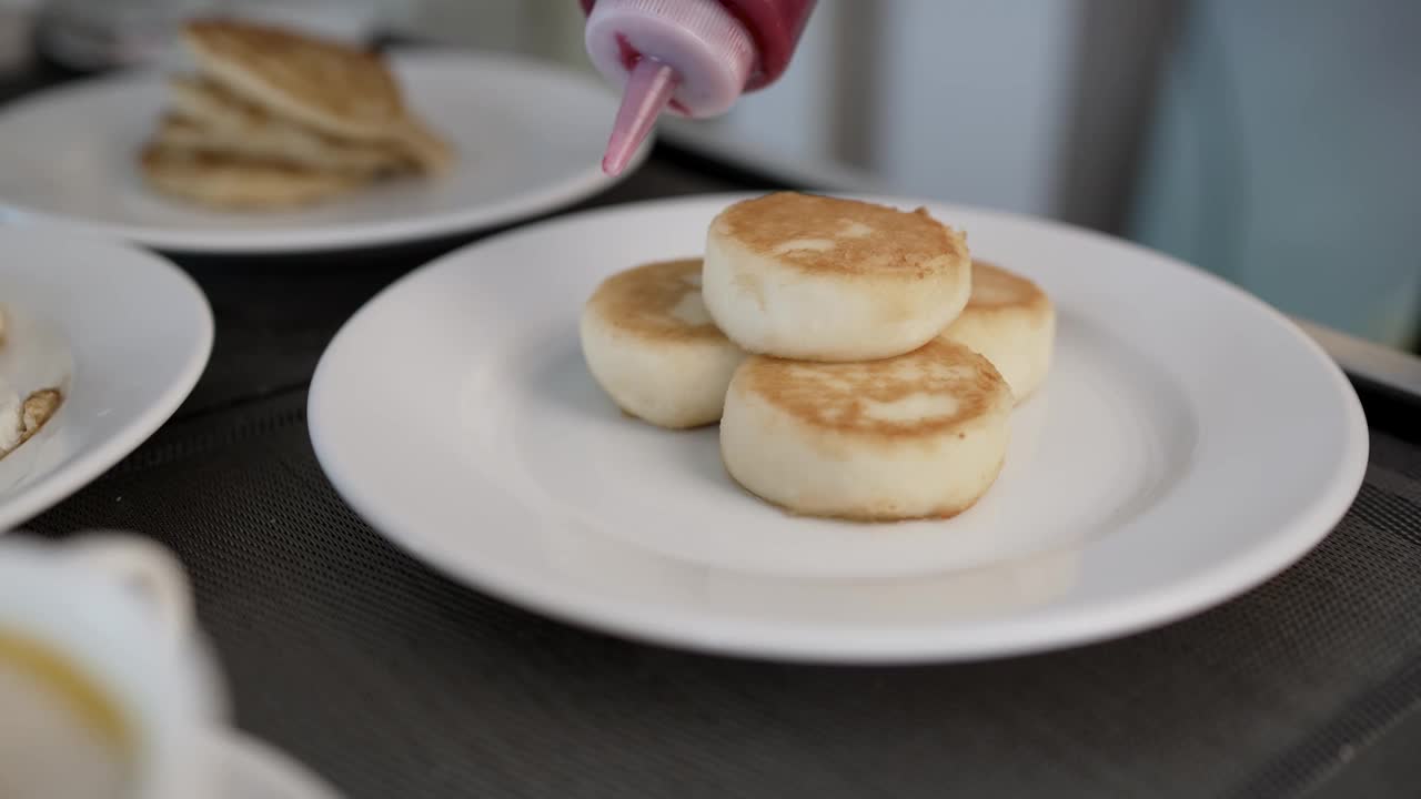 糖浆倒在煎饼的微距照片上。一滴糖浆特写。枫糖浆以慢动作倒在一叠煎饼上。早餐吃甜食，加糖浆的煎饼。视频下载