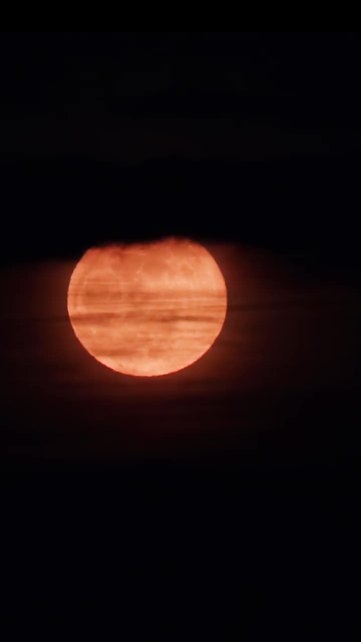 满月升上夜空，躲在乌云后面。月光下阴沉的夜空视频下载