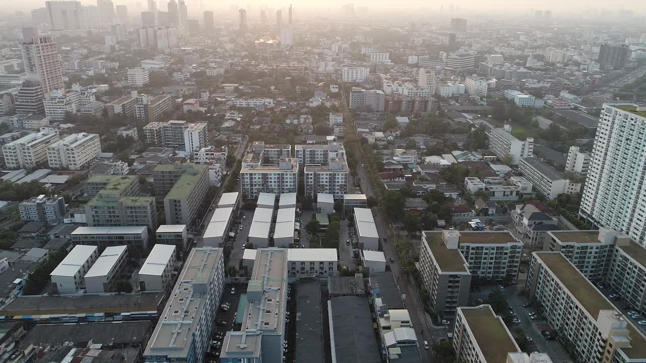 鸟瞰现代化的办公大楼和村庄，清晨的太阳升起曼谷大都市视频素材