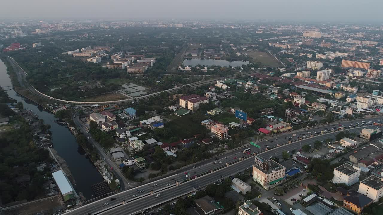 鸟瞰现代化的办公大楼和村庄，清晨的太阳升起曼谷大都市视频素材