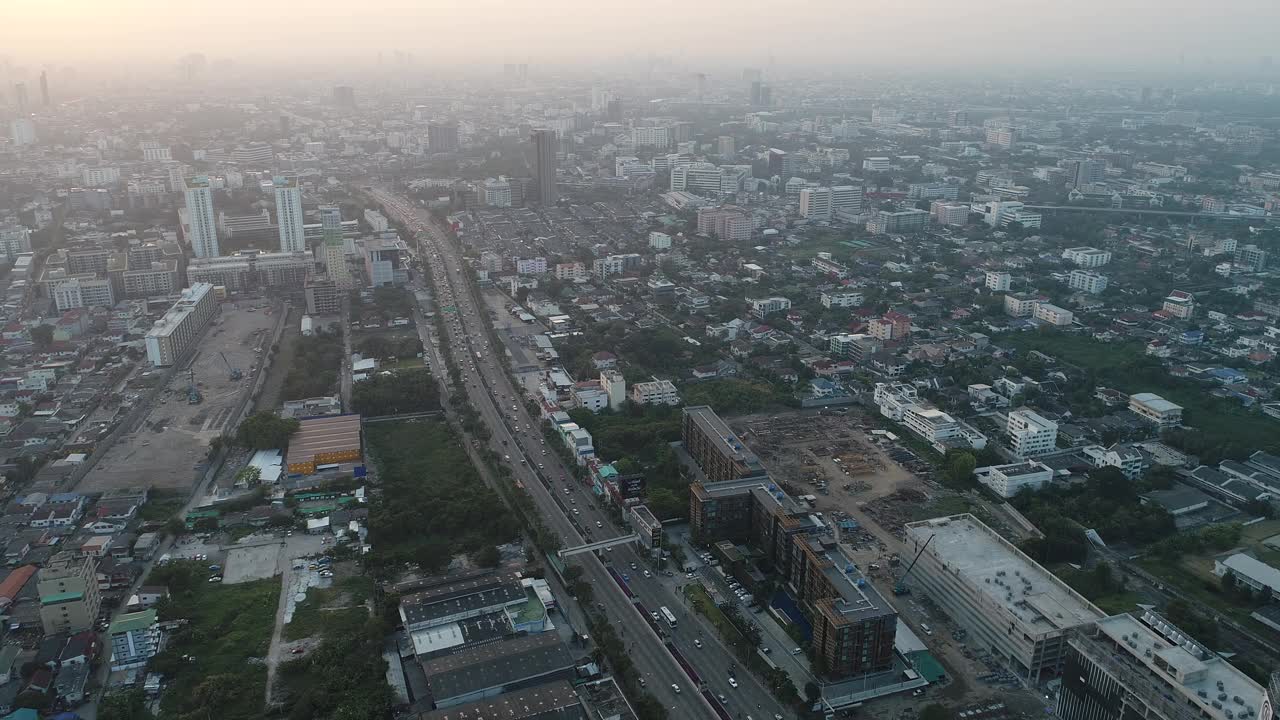 鸟瞰现代化的办公大楼和村庄，清晨的太阳升起曼谷大都市视频下载