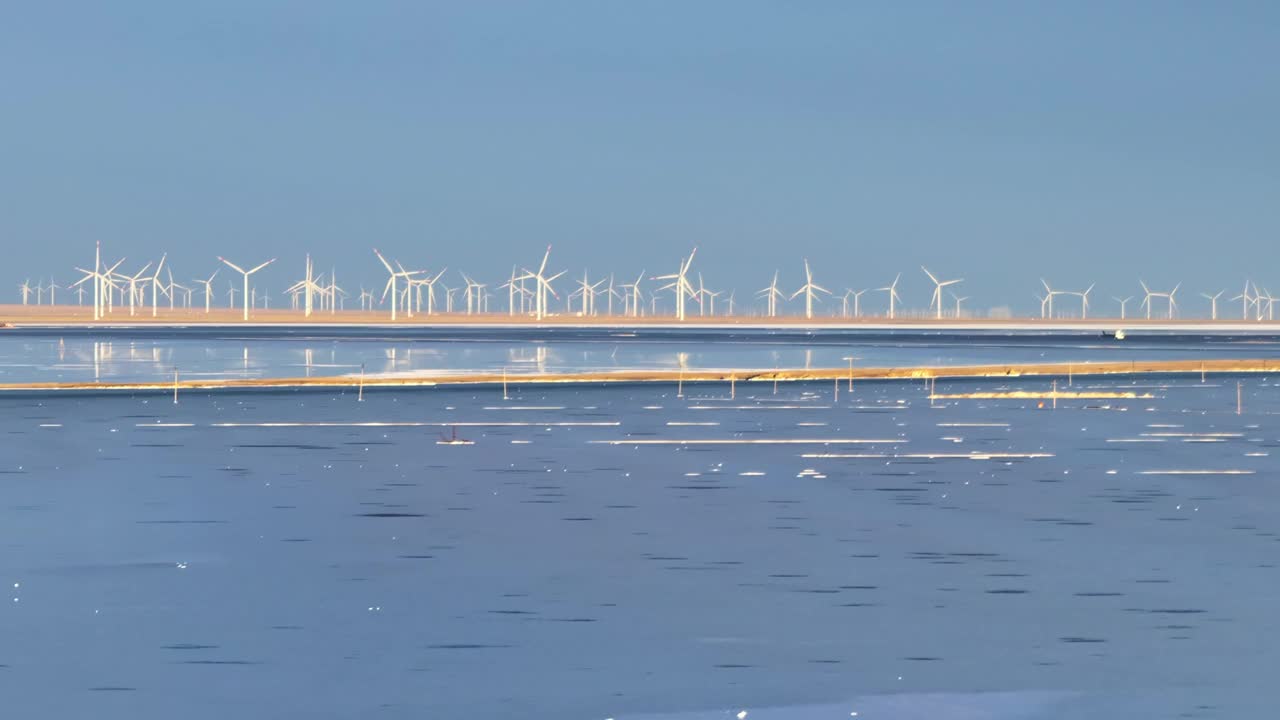 中国青海省茶卡盐湖和风电场附近的湖泊，笼罩在薄雾之中，旅游，可持续，能源的概念视频下载