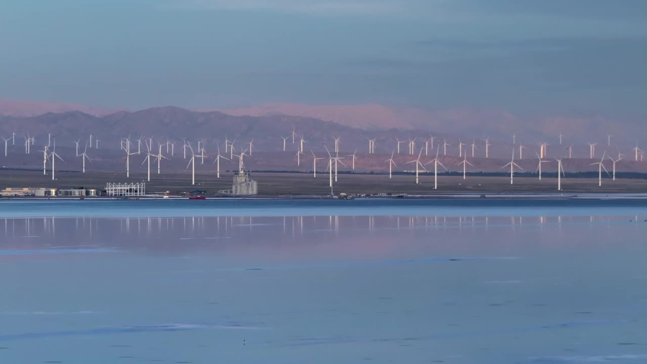 中国青海省茶卡盐湖和风电场附近的湖泊，笼罩在薄雾之中，旅游，可持续，能源的概念视频下载