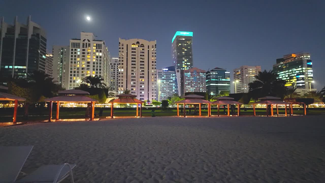 从公共海滩上看到的阿布扎比滨海住宅区的夜景视频下载