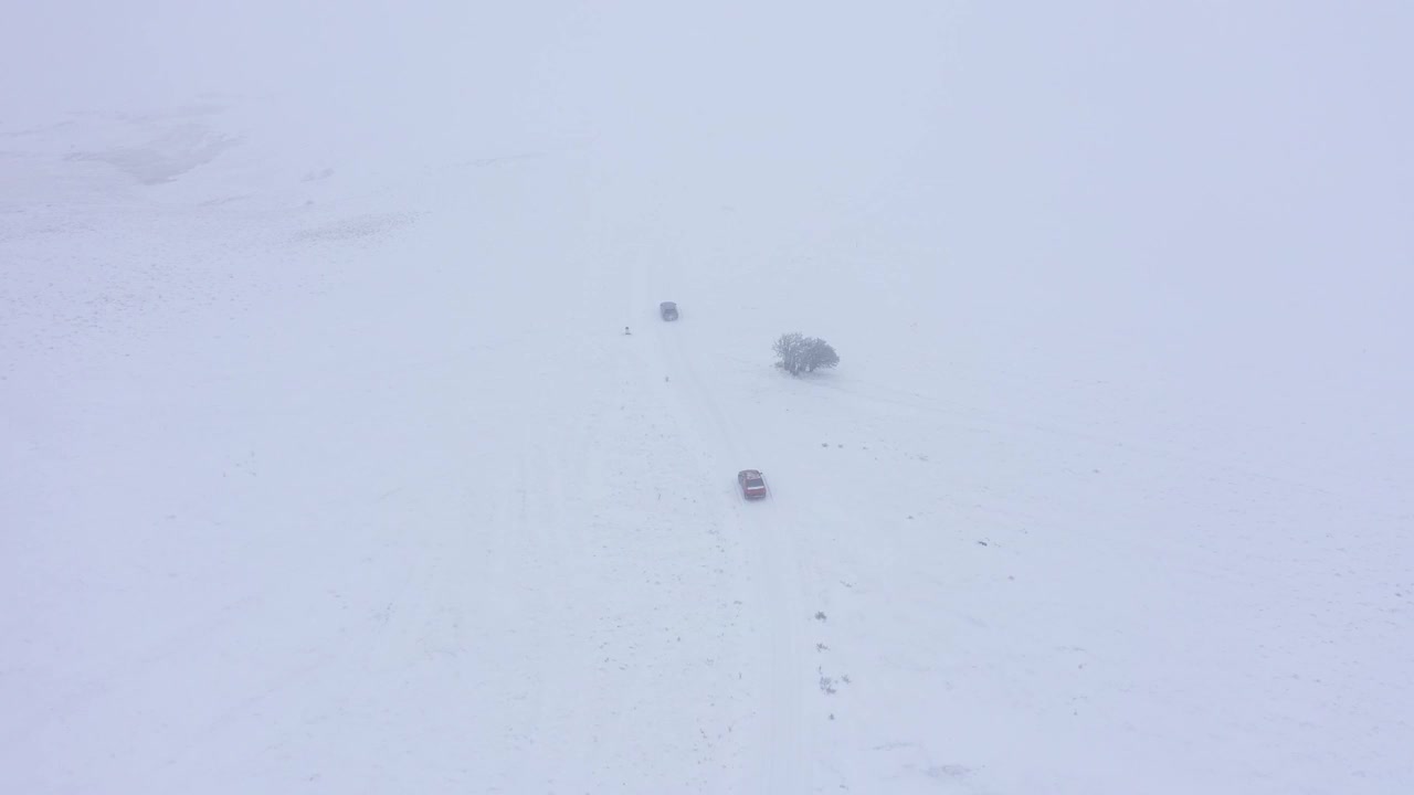 鸟瞰图，一辆汽车在雾蒙蒙的冬季道路上行驶视频下载