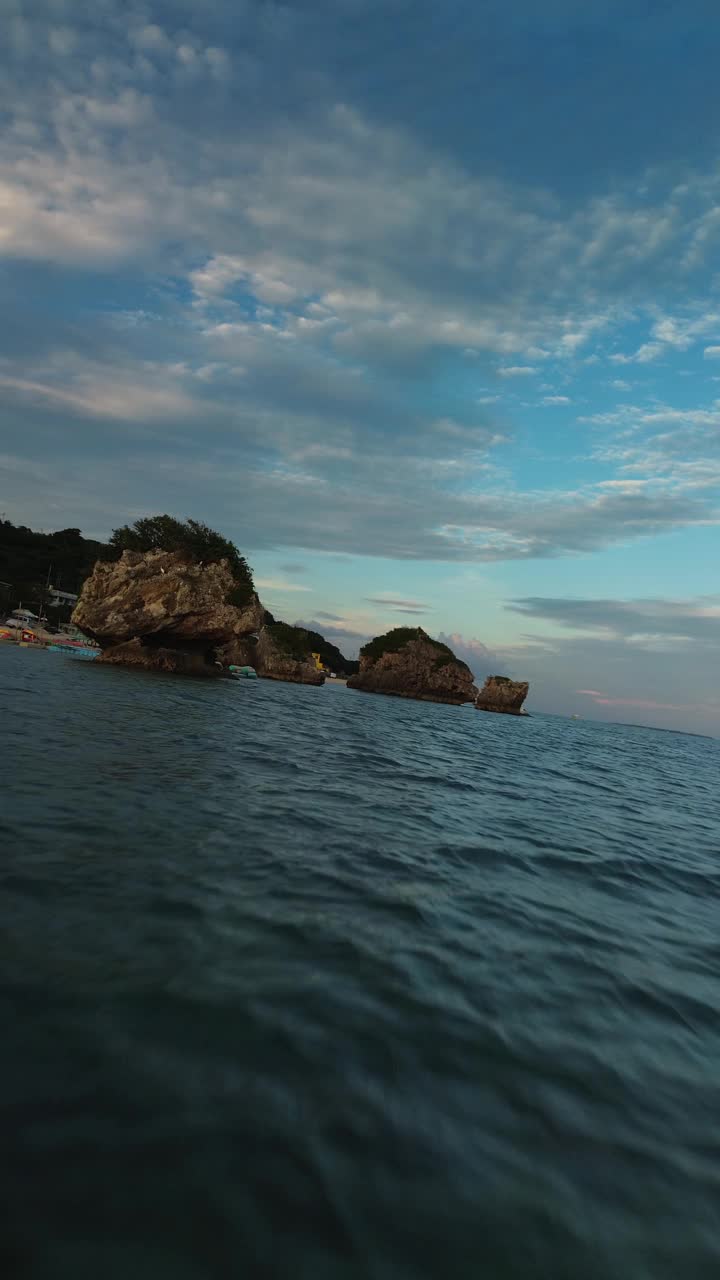 动态无人机飞行接近水下宁静的海景，美丽的岩石露头结合宁静的水域在日本冲绳视频素材