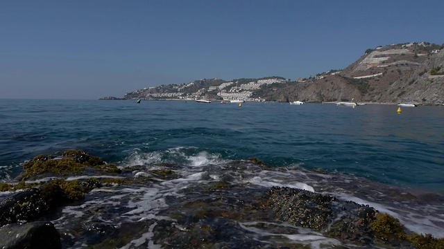 岩石和海浪，后面是海滩视频素材