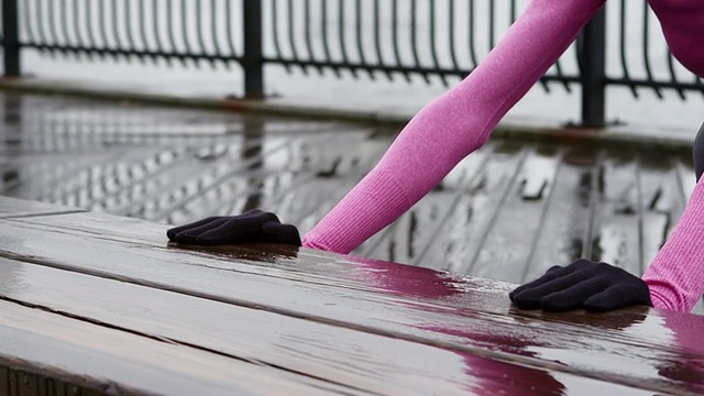 一个女人的近距离拉伸准备在雨中慢跑视频素材